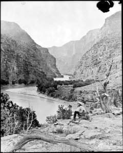 Gate of Lodore, Green River, N.W. Colorado^ *James C. Pilling sitting peacefully on the bank smoking his pipe and... - NARA - 517756
