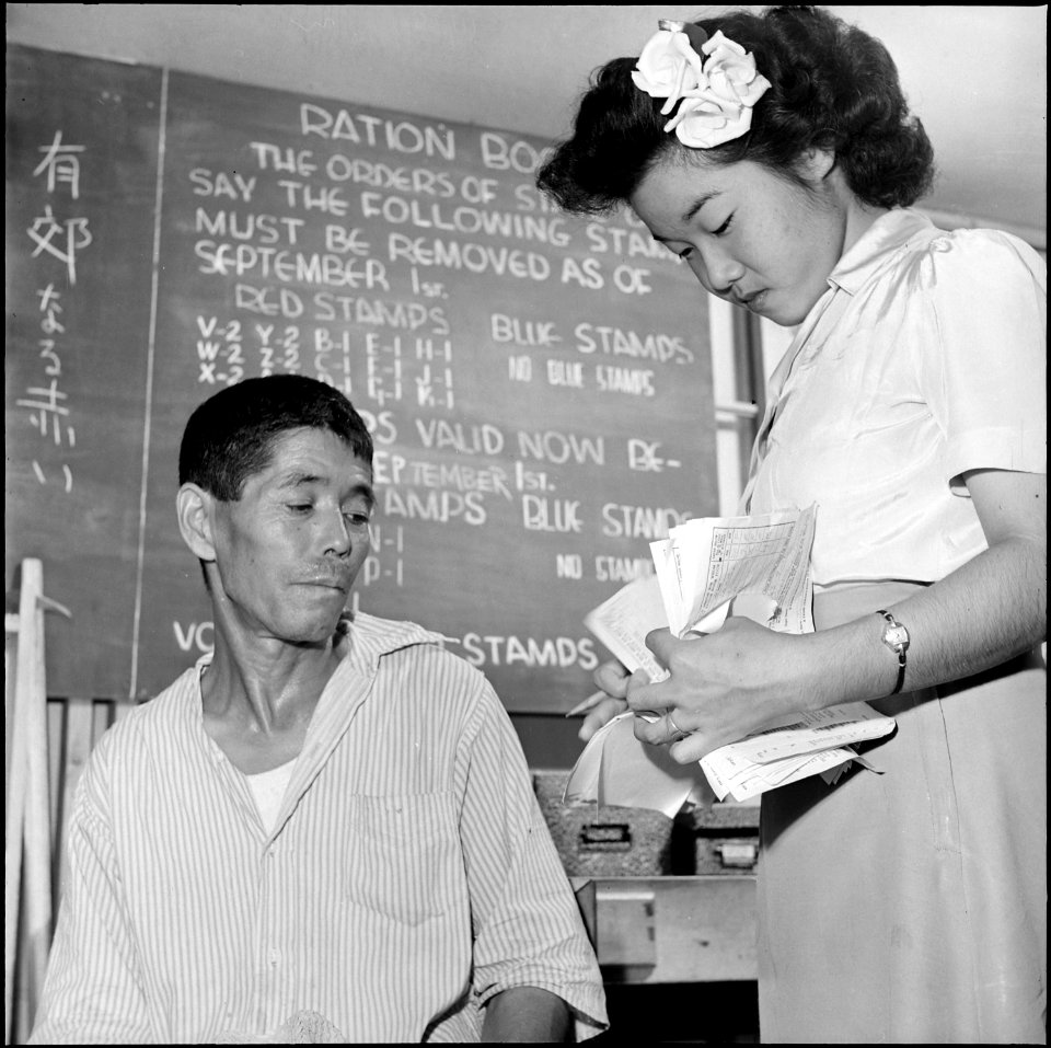 Gila River Relocation Center, Rivers, Arizona. A relocator receiving advice at the ration board off . . . - NARA - 539826