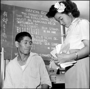 Gila River Relocation Center, Rivers, Arizona. A relocator receiving advice at the ration board off . . . - NARA - 539826