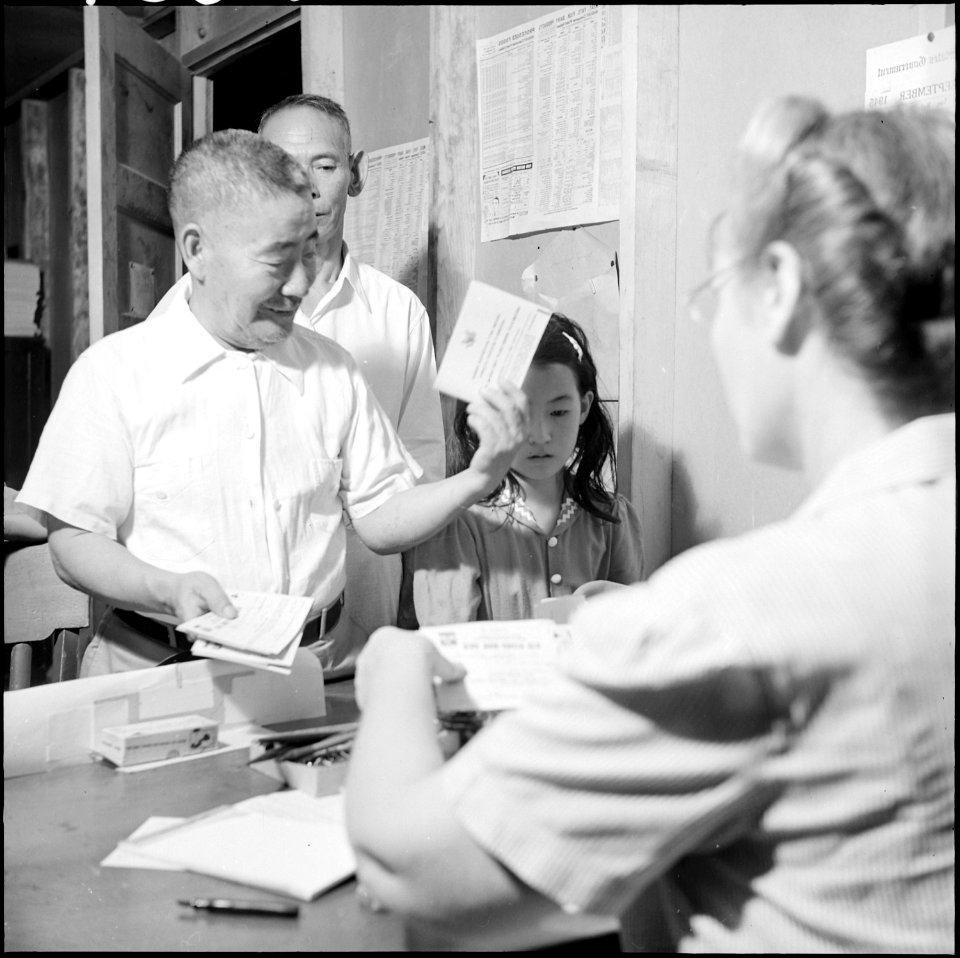 Gila River Relocation Center, Rivers, Arizona. A relocator receives a ration book prior to relocati . . . - NARA - 539853