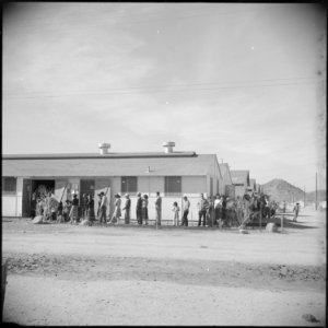 Gila River Relocation Center, Rivers, Arizona. A line of evacuees waiting for lunch at one of the m . . . - NARA - 538610 photo