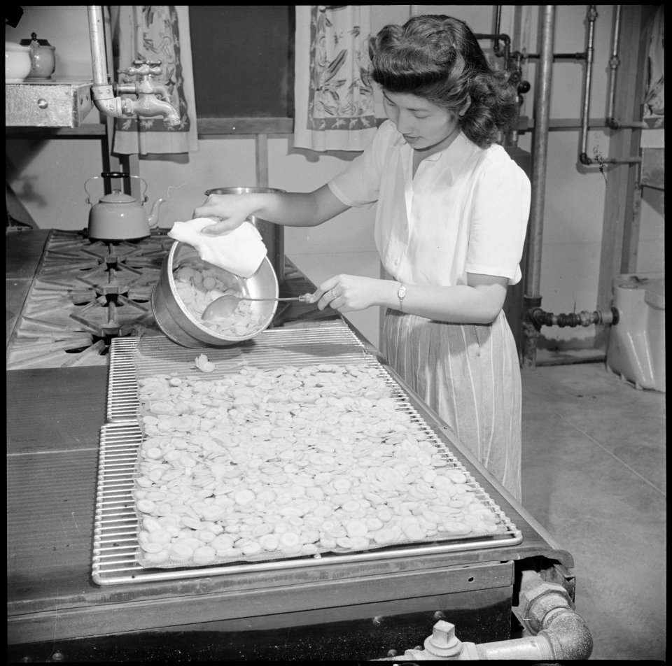 Gila River Relocation Center, Rivers, Arizona. Mary Sakai spreading carrots on drying trays. - NARA - 537062
