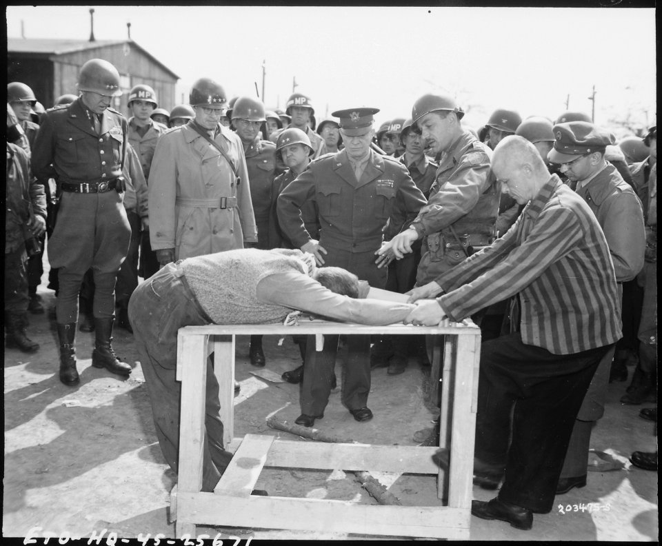 General Dwight D. Eisenhower watches grimly while occupants of a German concentration camp at Gotha demonstrate how... - NARA - 531263