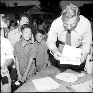 Gila River Relocation Center, Rivers, Arizona. Relocation Officer, William Husso, checking departur . . . - NARA - 539848
