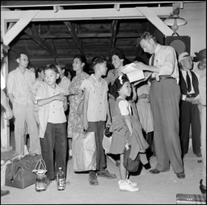 Gila River Relocation Center, Rivers, Arizona. Relocation Officer, William Husso, checking departu . . . - NARA - 539849
