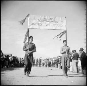 Gila River Relocation Center, Rivers, Arizona. Two of the evacuees carrying the J.A.C.L. banner in . . . - NARA - 538593