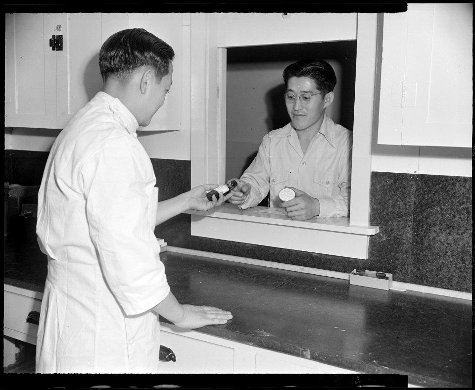 Granada Relocation Center, Amache, Colorado. A resident of the center receives a prepared prescript . . . - NARA - 539050