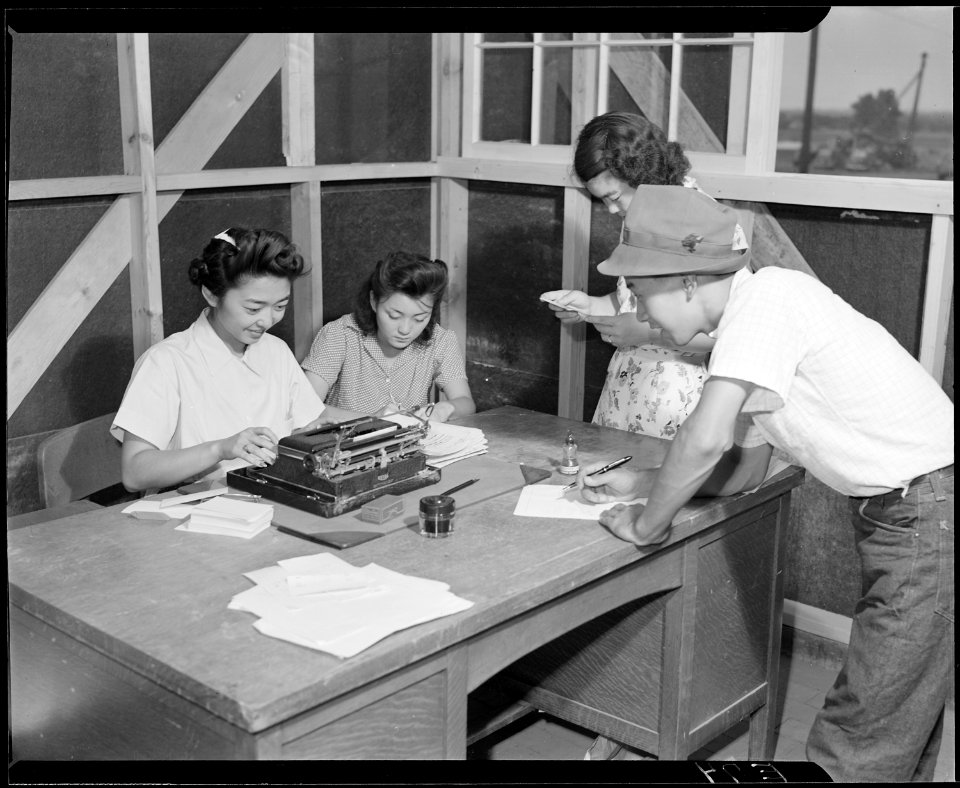 Granada Relocation Center, Amache, Colorado. A temporary timekeeping office is a busy spot as the f . . . - NARA - 538737