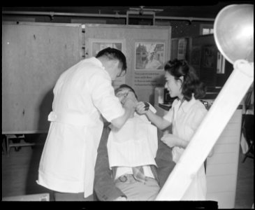 Granada Relocation Center, Amache, Colorado. A Japanese-American dentist and his assistant work on . . . - NARA - 539047