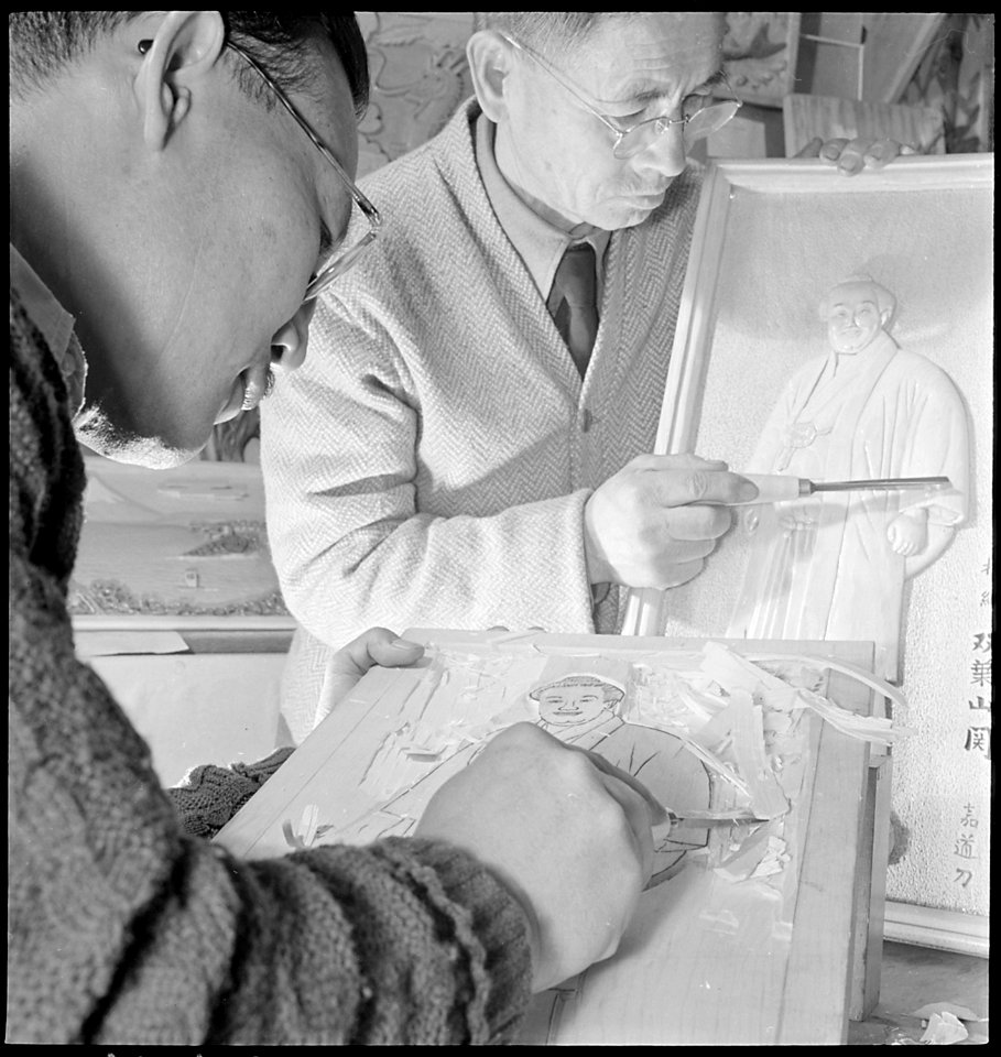 Granada Relocation Center, Amache, Colorado. A woodcarving demonstration by M.Y. Murakami, left, a . . . - NARA - 539304