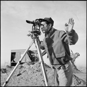 Granada Relocation Center, Amache, Colorado. A young Nisei operates a surveying instrument in layin . . . - NARA - 539126