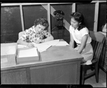Granada Relocation Center, Amache, Colorado. Esther Okuda, evacuee student registers with her socia . . . - NARA - 538740