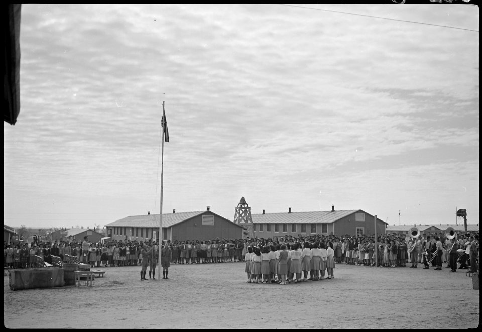 Granada Relocation Center, Amache, Colorado. High school assembly showing flag-raising ceremony. - NARA - 537169