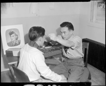 Granada Relocation Center, Amache, Colorado. In the optometry clinic, a resident is fitted with cor . . . - NARA - 539041