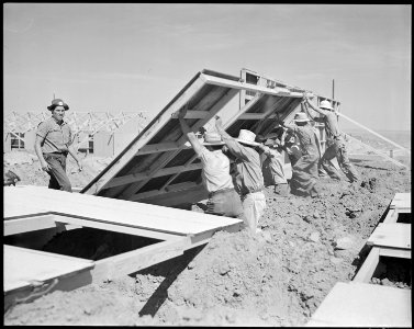 Granada Relocation Center, Amache, Colorado. Pre-fabricated wall sections are raised at the place b . . . - NARA - 538731