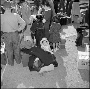 Granada Relocation Center, Amache, Colorado. Shown here is a young miss, dressed in her Sunday best . . . - NARA - 539908 photo