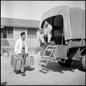 Granada Relocation Center, Amache, Colorado. Personal belongings being loaded in trucks and hauled . . . - NARA - 539939 photo