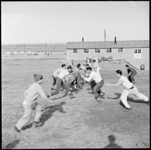 Granada Relocation Center, Amache, Colorado. Young center Niseis are football enthusiasts. Here du . . . - NARA - 539100