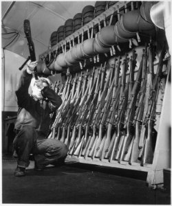 Group 4. Looking over guns in guard room. England, circa 1944. - NARA - 540070 photo