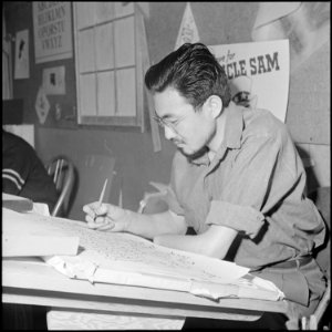 Heart Mountain Relocation Center, Heart Mountain, Wyoming. A young Nisei artist works on a letterin . . . - NARA - 539154