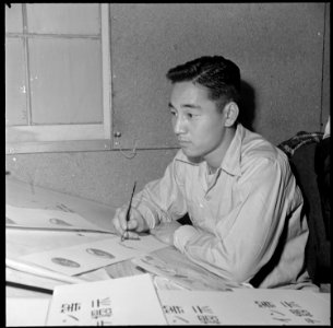 Heart Mountain Relocation Center, Heart Mountain, Wyoming. A young poster artist at work in the pos . . . - NARA - 539269