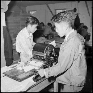 Heart Mountain Relocation Center, Heart Mountain, Wyoming. Editor Albert Saijo inspects a copy of . . . - NARA - 537158
