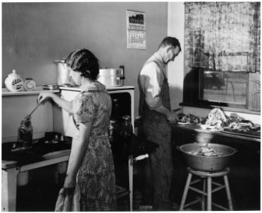Haskell County, Kansas. This farmer has just butchered a hog. Here, he and his wife are canning the . . . - NARA - 522160 photo