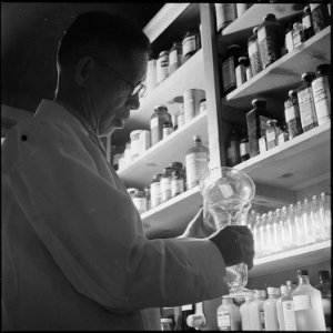 Heart Mountain Relocation Center, Heart Mountain, Wyoming. K. Ishijima, pharmacist, is shown at wor . . . - NARA - 539464 photo