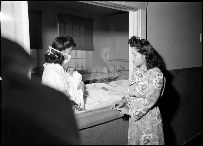 Heart Mountain Relocation Center, Heart Mountain, Wyoming. Mrs. Mari Yoshida looks at her baby thro . . . - NARA - 539443