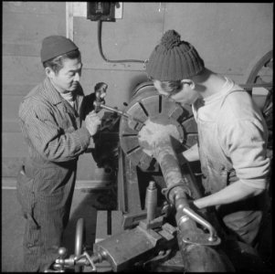 Heart Mountain Relocation Center, Heart Mountain, Wyoming. Two young Nisei machinists set up a truc . . . - NARA - 539246