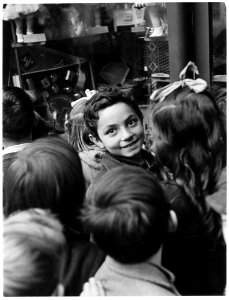 Iglesias, Italy. Along the Via Matteoti, main street of Iglesias, children stand entranced before a window display of... - NARA - 541738 photo