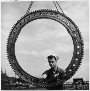 Installing a bearing ring on a 5 inch gun aboard a submarine at an advanced base. - NARA - 520837