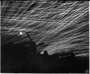 Japanese night raiders are greeted with a lacework of anti-aircraft fire by the Marine defenders of Yontan airfield... - NARA - 532363 photo
