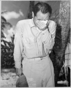 Japanese Prisoner of War at Guam, with bowed head after hearing Emperor Hirohito make announcement of Japan's... - NARA - 520990