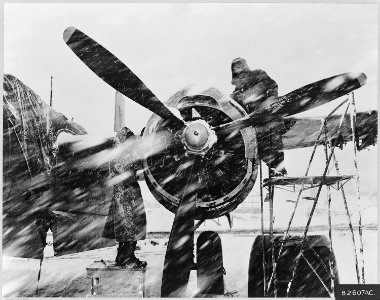Ignoring a Korean snow storm, two ground crew members of the 3rd Bomb Wing work on an engine of a U.S. Air Force... - NARA - 542255 photo
