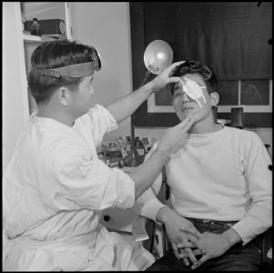 Jerome Relocation Center, Denson, Arkansas. Doctor Nobuo Renge applies an eye bandage to George Ari . . . - NARA - 539321