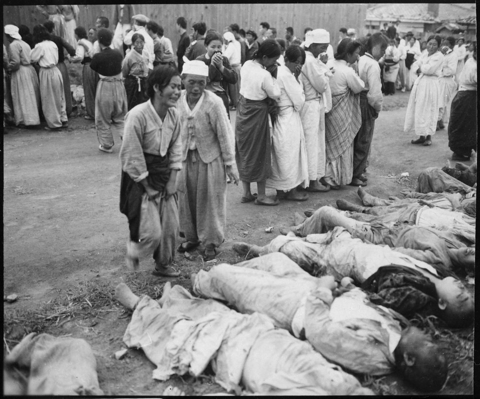 Koreans from Hamhung identify the bodies of some 300 political prisoners who were killed by the North Korean Army by... - NARA - 531380