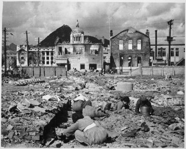 Korean women and children search the rubble of Seoul for anything that can be used or burned as fuel. - NARA - 531386 photo