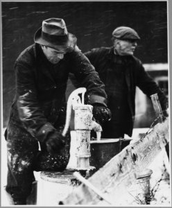 Landaff, Grafton County, New Hampshire. Mr. Amos and his son are pumping out the tank of this carbid . . . - NARA - 521451
