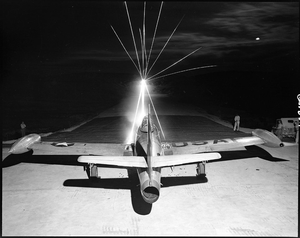 Leaving a fiery trail, .50 caliber bullets streak through the night as maintenance men of the 49th Fighter Bomber... - NARA - 542257