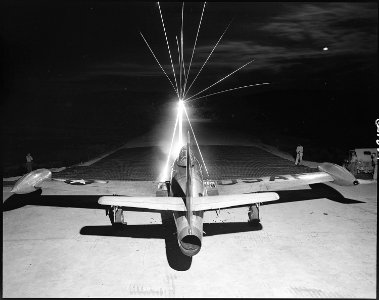 Leaving a fiery trail, .50 caliber bullets streak through the night as maintenance men of the 49th Fighter Bomber... - NARA - 542257