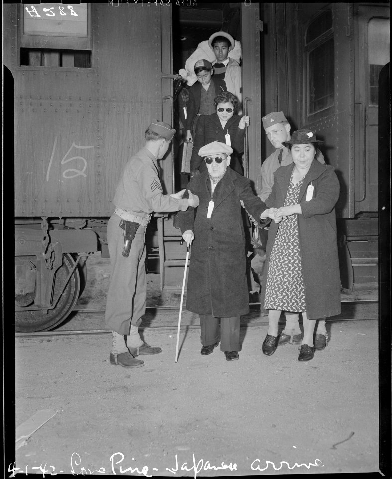 Lone Pine, California. Evacuees of Japanese ancestry arrive here by train and await buses for Manza . . . - NARA - 536229