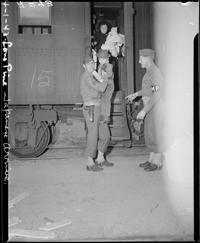 Lone Pine, California. Persons of Japanese ancestry being helped from the train by Military Police . . . - NARA - 536233