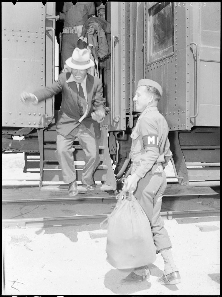 Lone Pine, California. Soldier of Army military police assists evacuees with baggage as they arrive . . . - NARA - 538492
