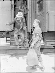 Lone Pine, California. Soldier of Army military police assists evacuees with baggage as they arrive . . . - NARA - 538492