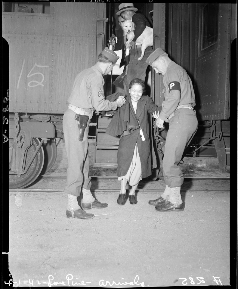 Lone Pine, California. Soldiers assist elderly evacuee of Japanese descent leave car steps in trans . . . - NARA - 536226