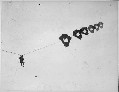 Lieutenant Kirk Booth of the U.S. Signal Corps being lifted skyward by the giant Perkins man-carrying kite at Camp... - NARA - 533662