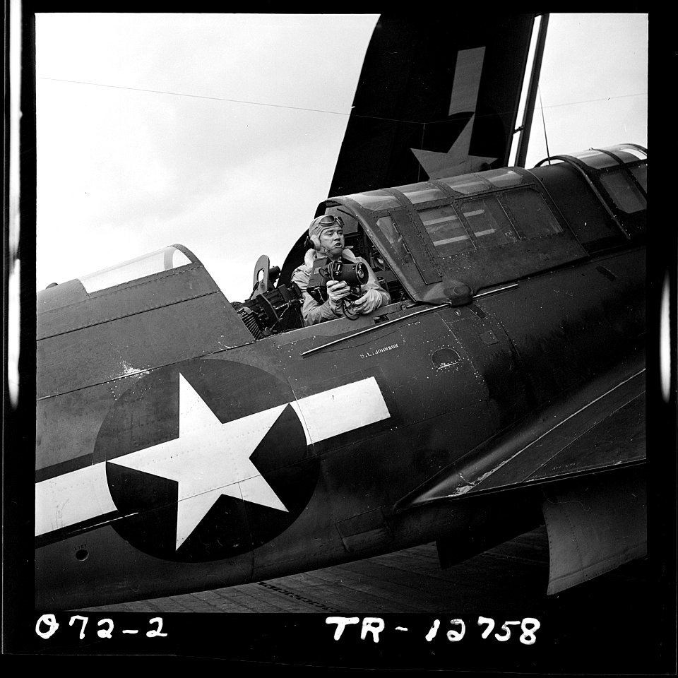 Lt. Barrett Gallagher in rear seat of SB2C that has just landed on a carrier. He holds a K-25 camera he was using. - NARA - 520844