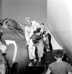 Lt. Charles E. Kerlee, USNR, steps down from the wing of a TBF after photographing the raid on Wake. Using two K-20... - NARA - 520610