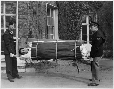 Major Milton Erdel (left), and Lieutenant J. H. Shuford, demonstrate that it is impossible for a patient to fall out... - NARA - 531497 photo